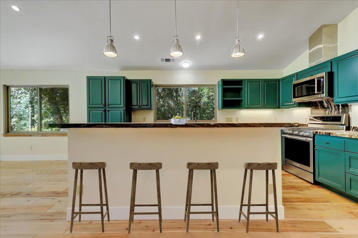 18955 Lake City Road Nevada City, CA 95959 - Photo 47 of 99 a kitchen with stainless steel appliances kitchen island granite countertop a stove a sink and a microwave