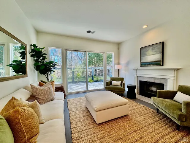 a living room with furniture large window and a fireplace