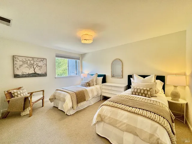 a bedroom with two beds and painting on the wall