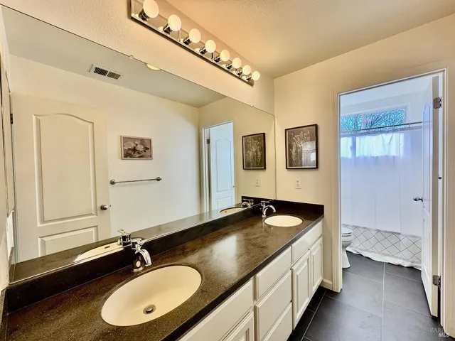 a bathroom with a granite countertop sink and a mirror