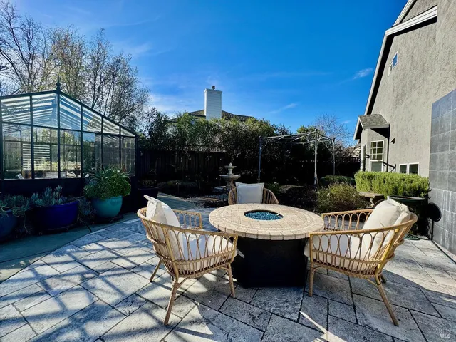 a view of a patio with a dining table and chairs with a fire pit