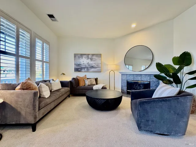 a living room with furniture a fireplace and a large window