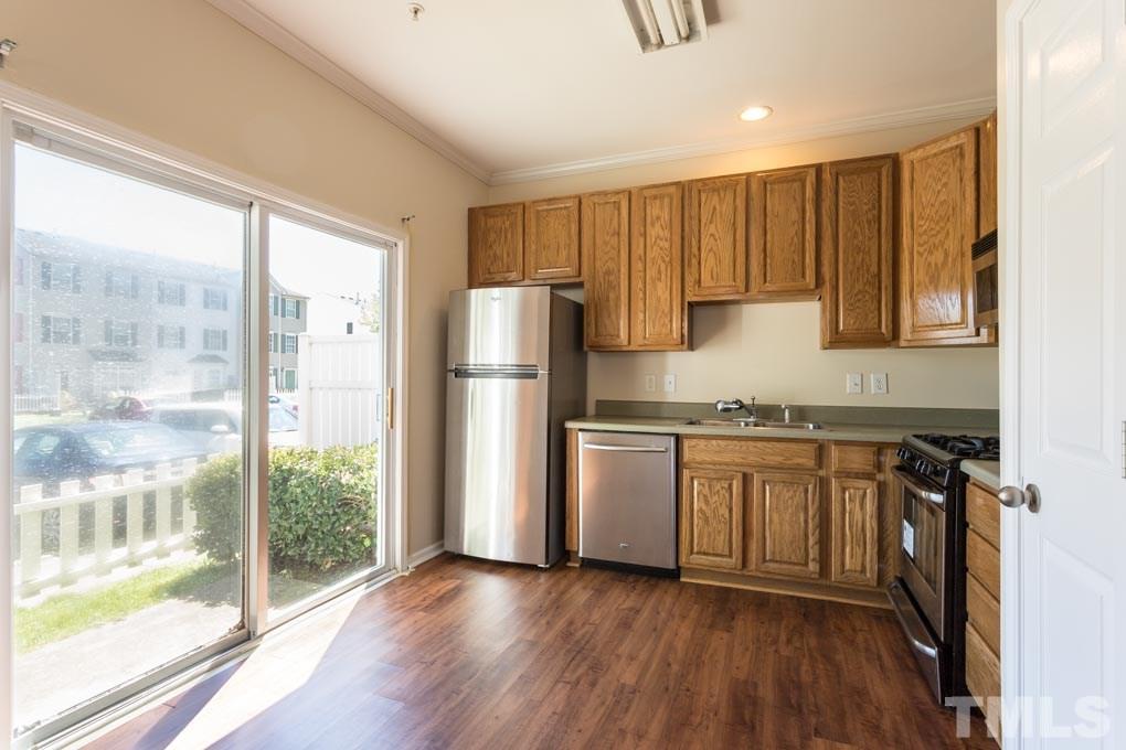 5110 Neuse Commons Lane, Unit 100 Raleigh, NC 27616 - Photo 11 of 27 a kitchen with granite countertop a refrigerator a sink and a stove top oven
