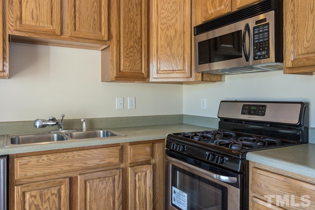 5110 Neuse Commons Lane, Unit 100 Raleigh, NC 27616 - Photo 13 of 27 a kitchen with stainless steel appliances granite countertop a stove and a microwave