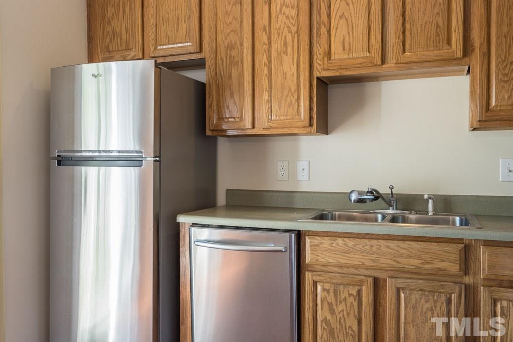 5110 Neuse Commons Lane, Unit 100 Raleigh, NC 27616 - Photo 14 of 27 a kitchen with stainless steel appliances granite countertop a refrigerator and a sink