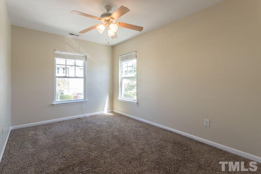 5110 Neuse Commons Lane, Unit 100 Raleigh, NC 27616 - Photo 18 of 27 an empty room with windows and fan