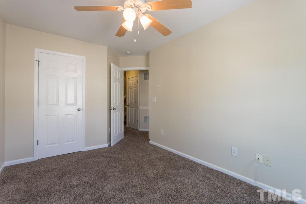 5110 Neuse Commons Lane, Unit 100 Raleigh, NC 27616 - Photo 19 of 27 an empty room with a fan and a chandelier fan