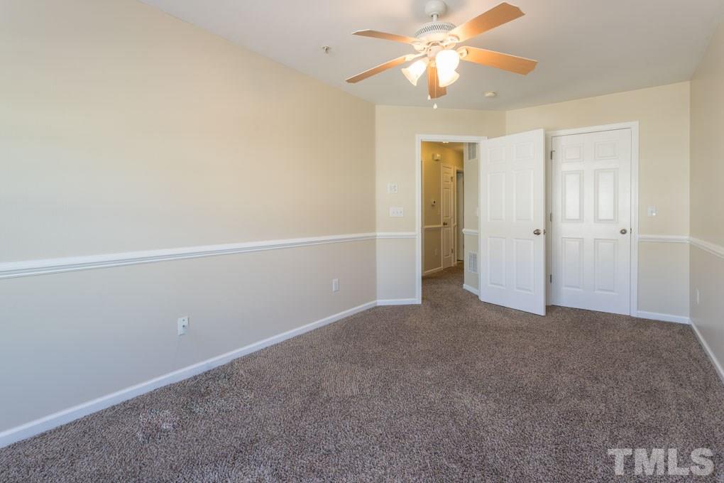 5110 Neuse Commons Lane, Unit 100 Raleigh, NC 27616 - Photo 21 of 27 an empty room with closet and a ceiling fan