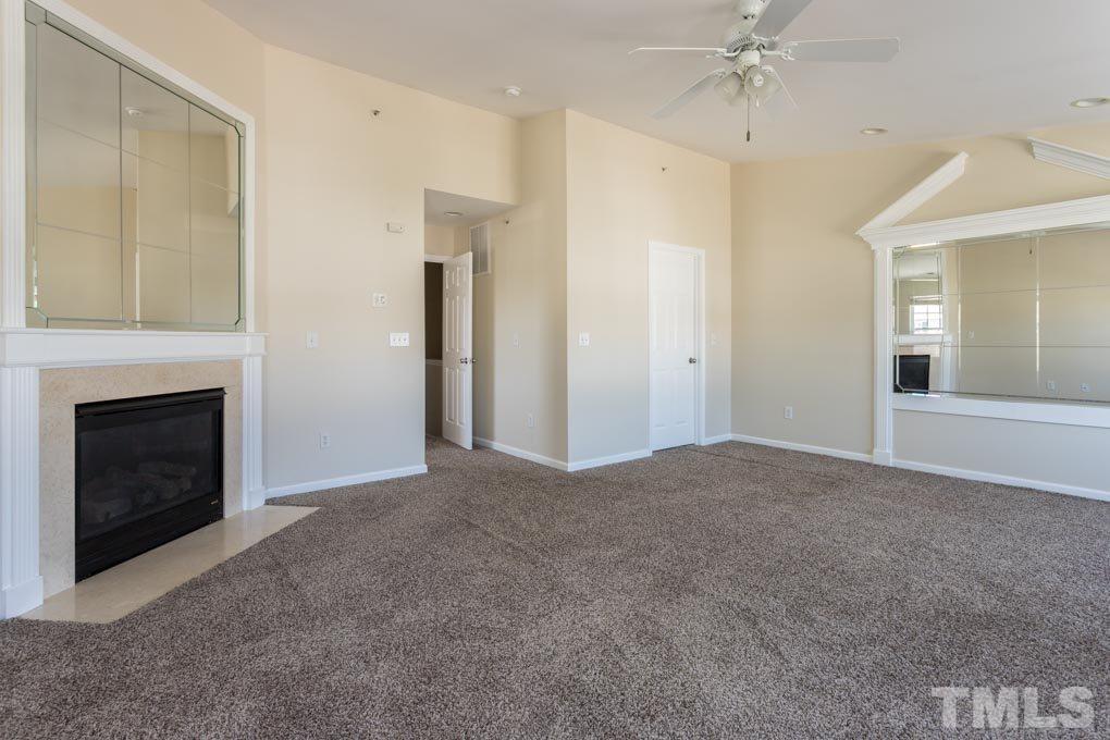 5110 Neuse Commons Lane, Unit 100 Raleigh, NC 27616 - Photo 24 of 27 a view of a livingroom with a fireplace and chandelier fan
