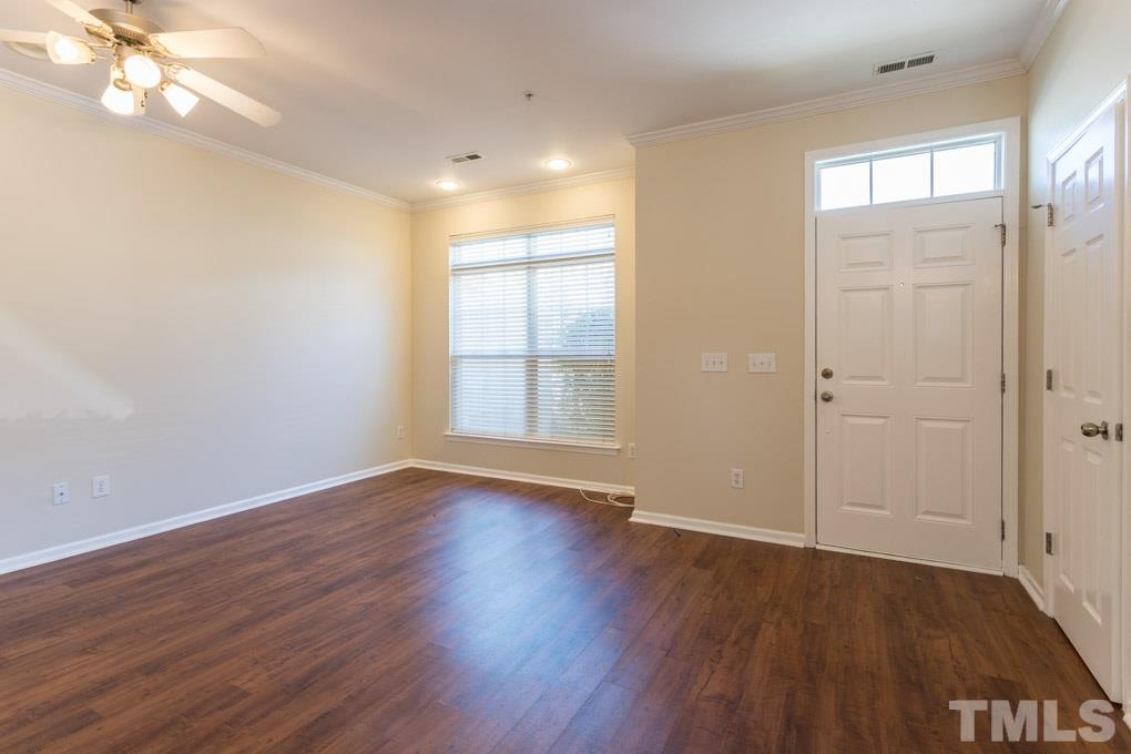 5110 Neuse Commons Lane, Unit 100 Raleigh, NC 27616 - Photo 8 of 27 a view of an empty room with wooden floor and a window