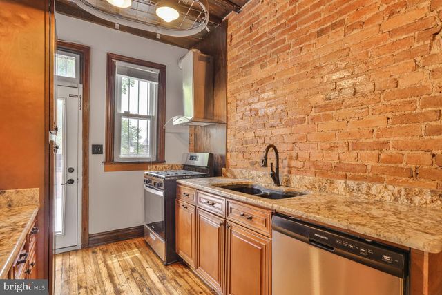 a kitchen with stainless steel appliances granite countertop a sink a stove and a refrigerator