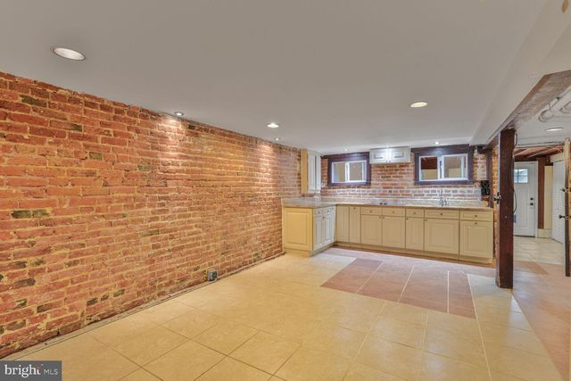 a view of kitchen with stainless steel appliances granite countertop a sink and cabinets