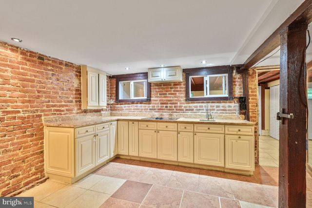 a spacious bathroom with granite countertop a sink a mirror and a bathtub