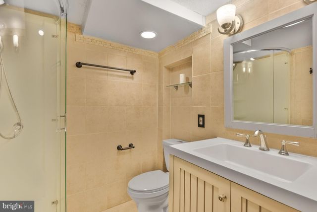 a bathroom with a granite countertop sink a toilet and a shower