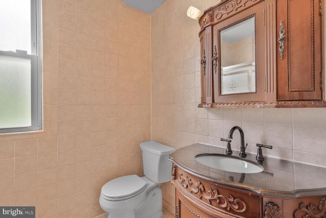 a bathroom with a toilet a sink and mirror