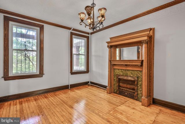 a view of an empty room with a fireplace and a window