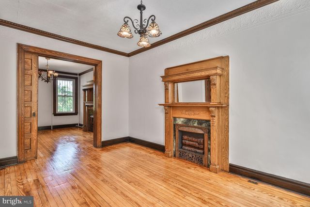 wooden floor fireplace and windows in an empty room