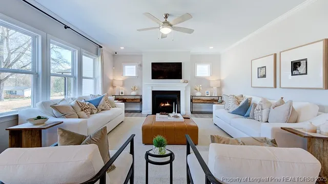 a living room with furniture a flat screen tv and a fireplace