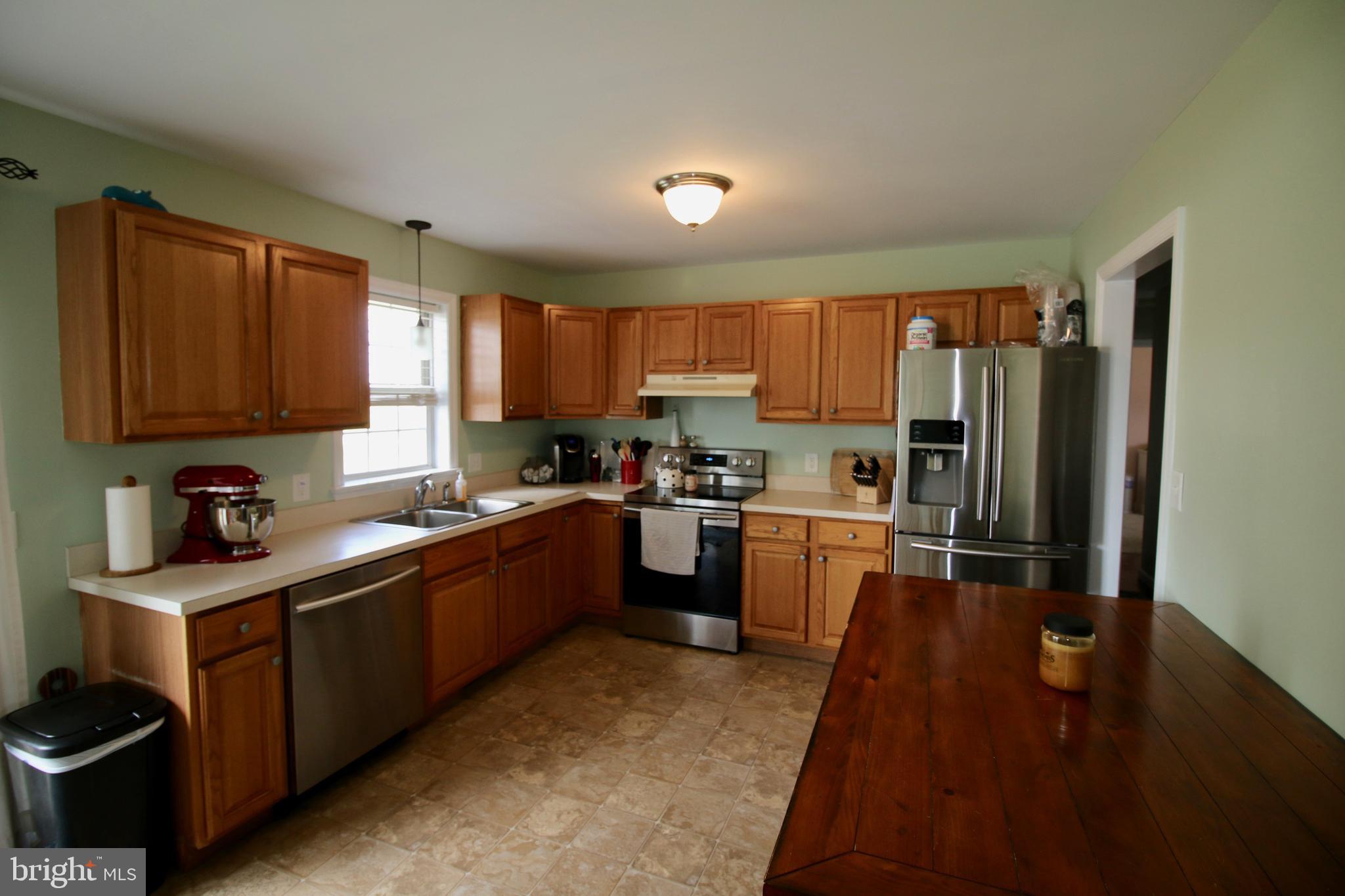 1314 Rawlinsville Road New Providence, PA 17560 - Photo 6 of 22 a kitchen with stainless steel appliances granite countertop a refrigerator sink and wooden cabinets
