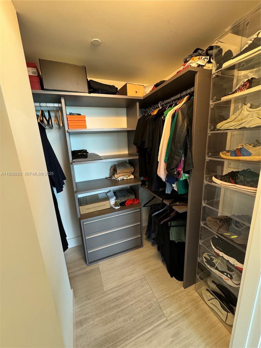 1451 Brickell Avenue, Unit 1105 Miami, FL 33131 - Photo 13 of 43 a view of walk in closet with clothes and shoes