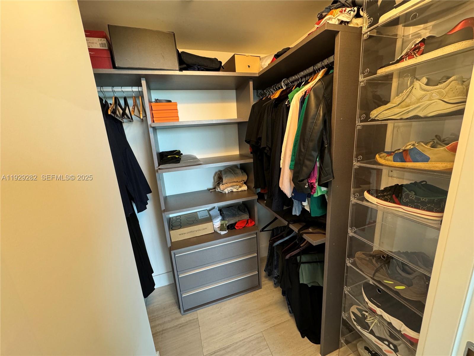 1451 Brickell Avenue, Unit 1105 Miami, FL 33131 - Photo 14 of 43 a view of walk in closet with clothes and shoes
