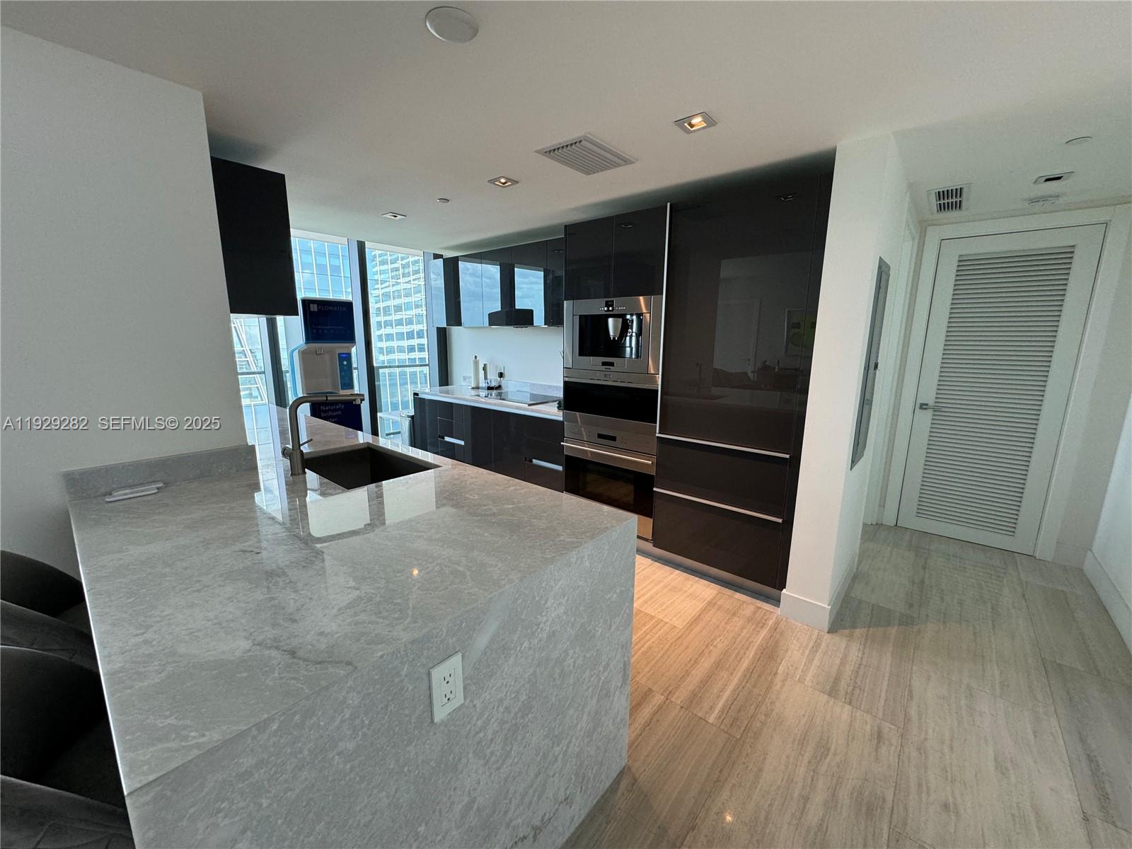 1451 Brickell Avenue, Unit 1105 Miami, FL 33131 - Photo 15 of 43 a living room with stainless steel appliances kitchen island granite countertop a refrigerator a stove and a wooden floors