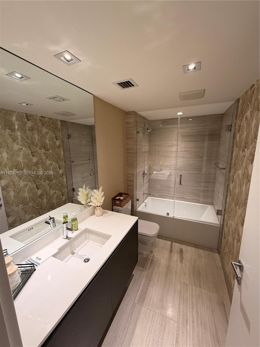 1451 Brickell Avenue, Unit 1105 Miami, FL 33131 - Photo 2 of 43 a bathroom with a bathtub double vanity sink and a large mirror