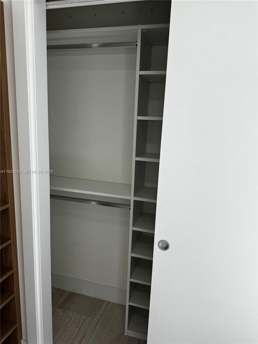 1451 Brickell Avenue, Unit 1105 Miami, FL 33131 - Photo 42 of 43 a view of walk in closet with empty racks