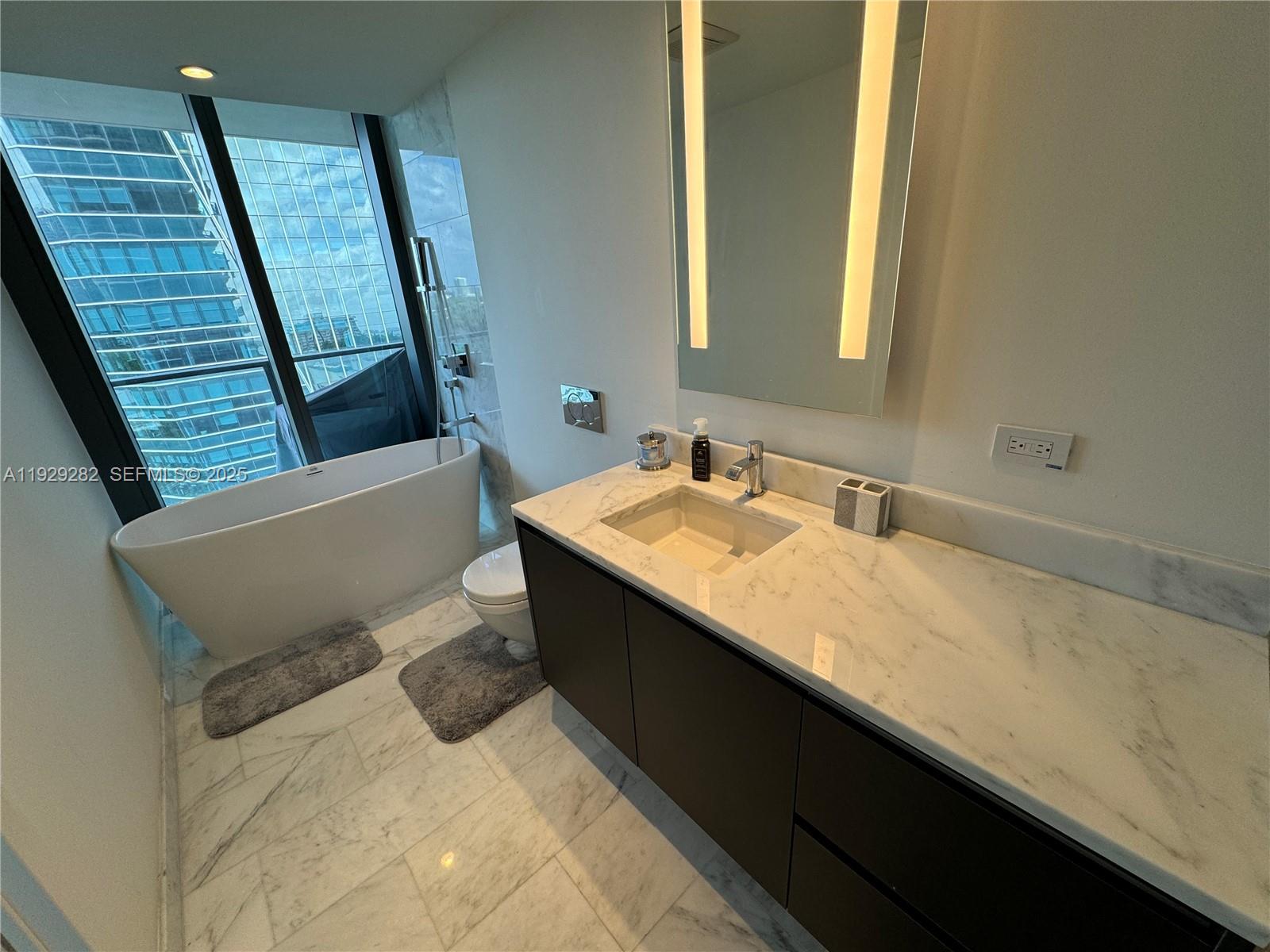 1451 Brickell Avenue, Unit 1105 Miami, FL 33131 - Photo 10 of 43 a bathroom with a sink and a mirror