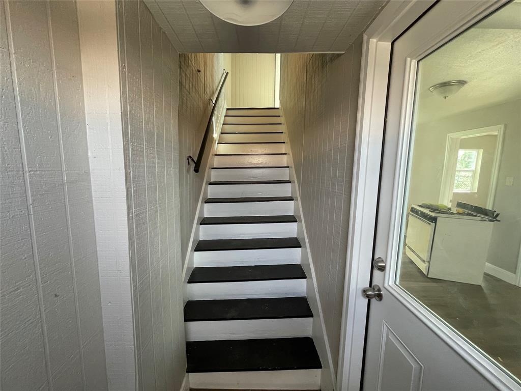 a view of a hallway with wooden floor and stairs