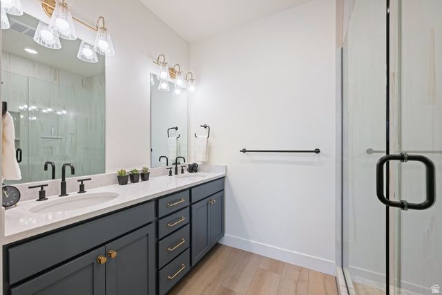 762 West Periwinkle Lane, Unit 102 St. George, UT 84790 - Photo 16 of 40 Full bath featuring a shower stall, double vanity, and light wood-style floors