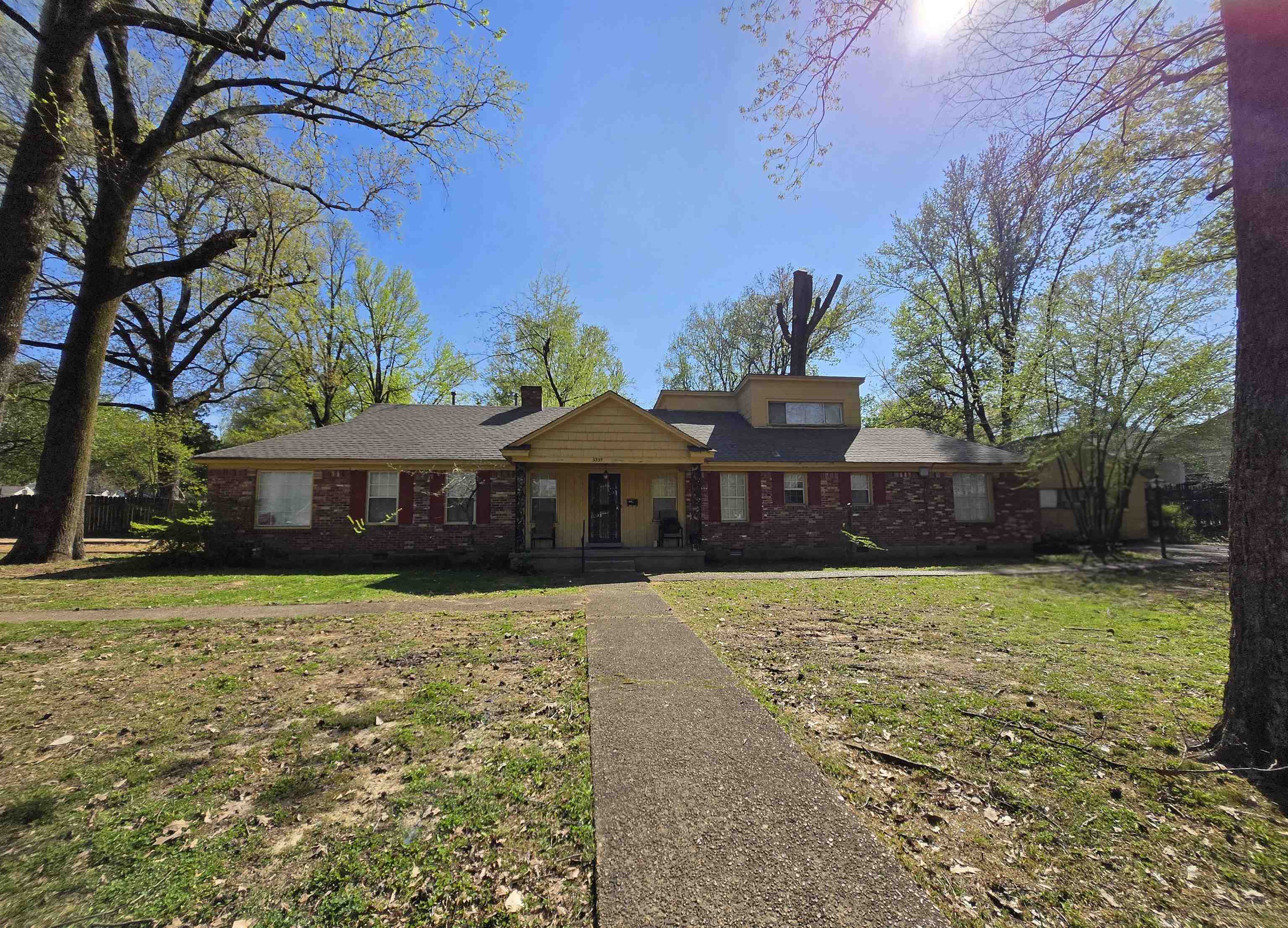 View of front of home featuring a front yard, brick siding, a porch, and roof with shingles