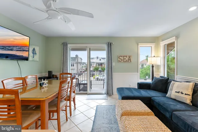 a living room with furniture a flat screen tv and a large window