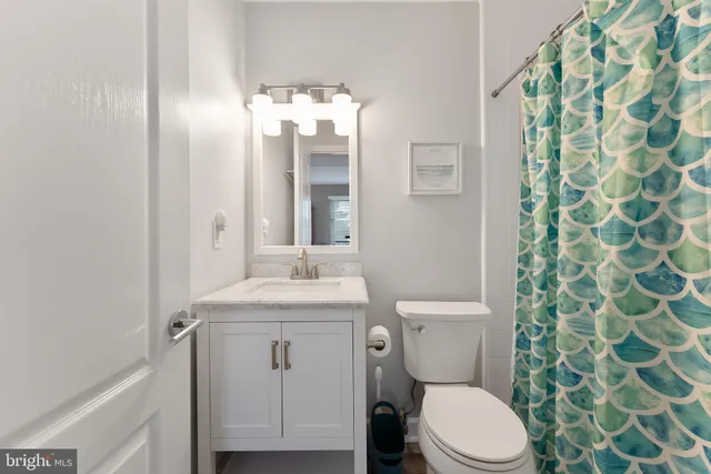 a bathroom with a granite countertop toilet sink and mirror