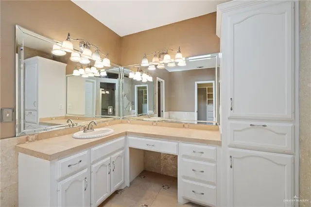 a bathroom with a sink vanity and a mirror