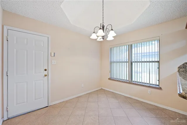 a view of a livingroom with a chandelier fan and windows