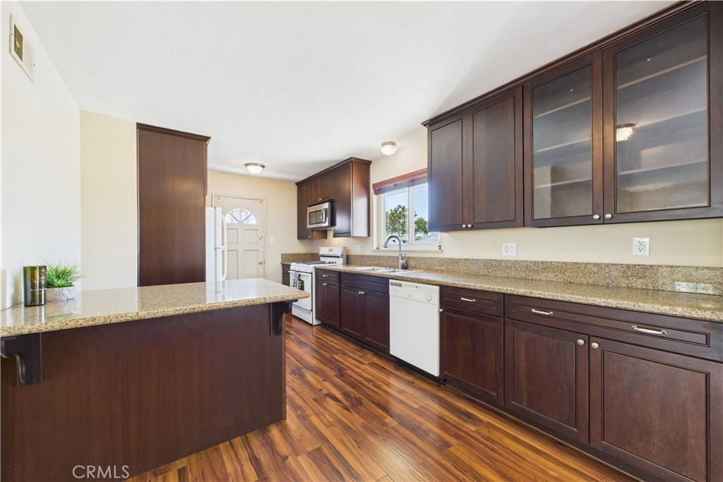 a large kitchen with stainless steel appliances granite countertop wooden cabinets a sink and dishwasher