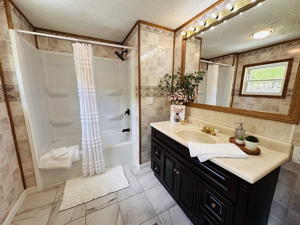 93 Grochmal Avenue, Unit 119 Springfield, MA 01151 - Photo 21 of 33 a spacious bathroom with a sink a mirror a bathtub and shower