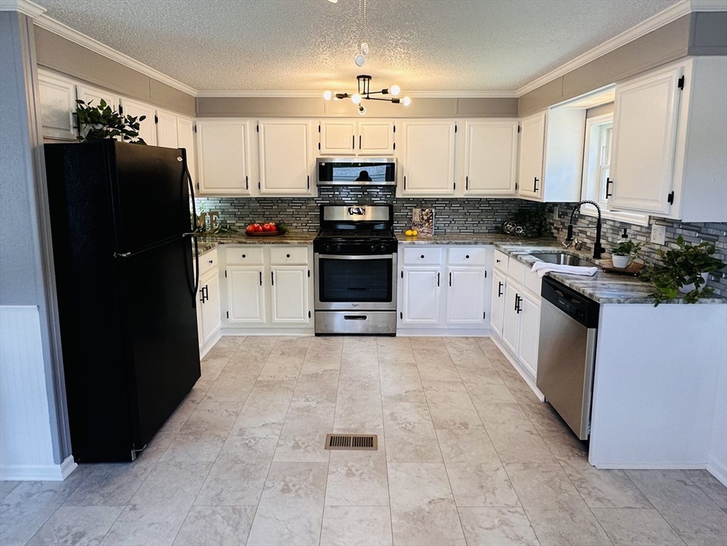 93 Grochmal Avenue, Unit 119 Springfield, MA 01151 - Photo 5 of 33 a kitchen with granite countertop a refrigerator and a stove top oven