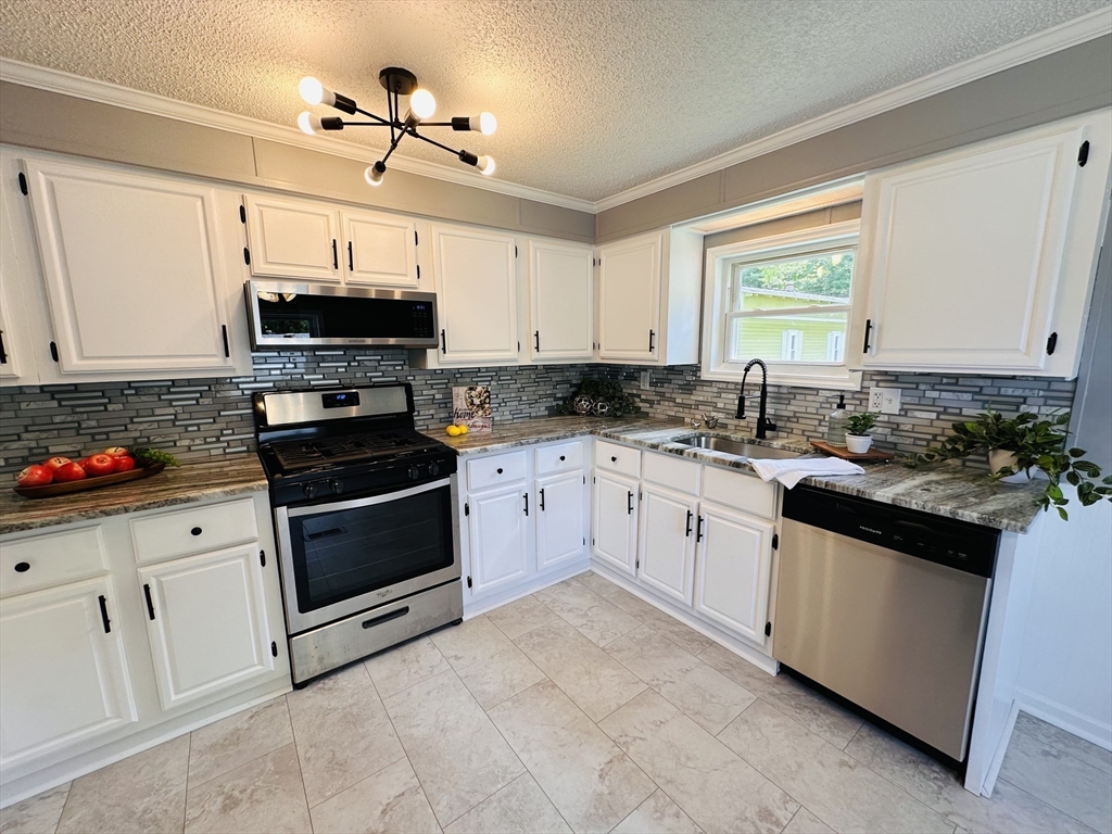 93 Grochmal Avenue, Unit 119 Springfield, MA 01151 - Photo 7 of 33 a kitchen with granite countertop a sink a stove and cabinets