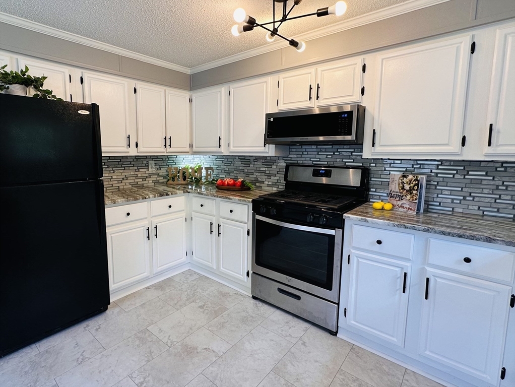 93 Grochmal Avenue, Unit 119 Springfield, MA 01151 - Photo 9 of 33 a kitchen with stainless steel appliances a stove microwave and cabinets