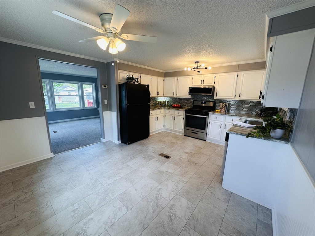 93 Grochmal Avenue, Unit 119 Springfield, MA 01151 - Photo 10 of 33 a kitchen with kitchen island wooden cabinets and refrigerator