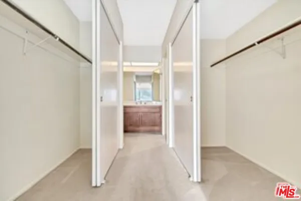 a view of a hallway with a livingroom and a bathroom with a sink