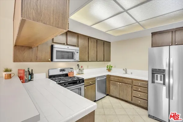 a kitchen with a sink cabinets and stainless steel appliances