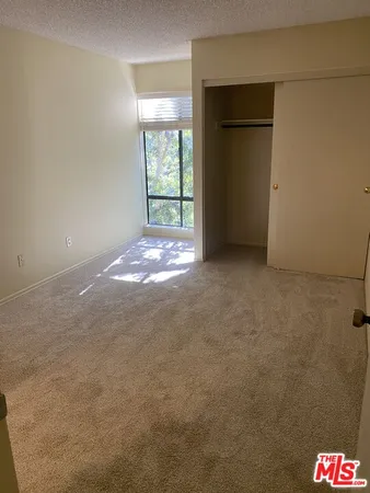 an empty room with windows and closet