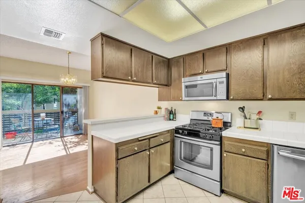 a kitchen with a stove sink and cabinets
