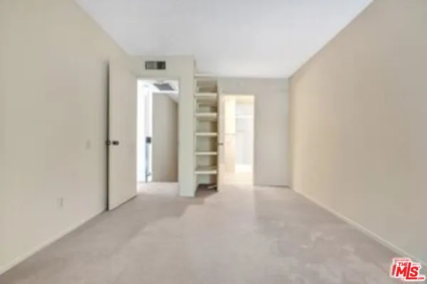an empty room with closet and a window
