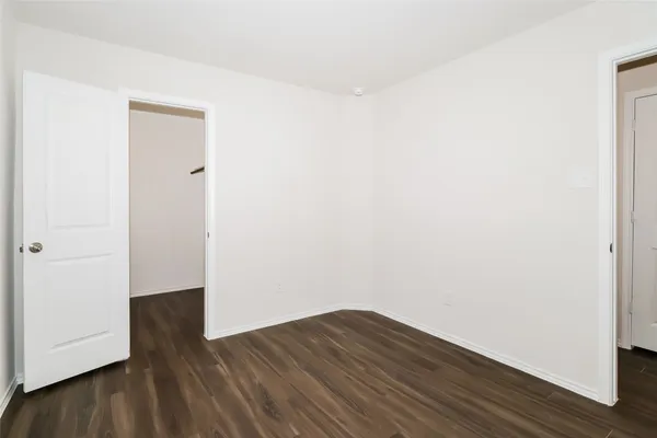 a view of a small space with wooden floor and a window