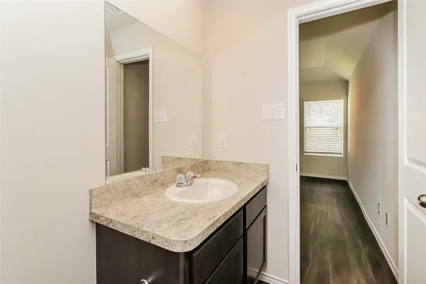 a bathroom with a granite countertop sink and a mirror