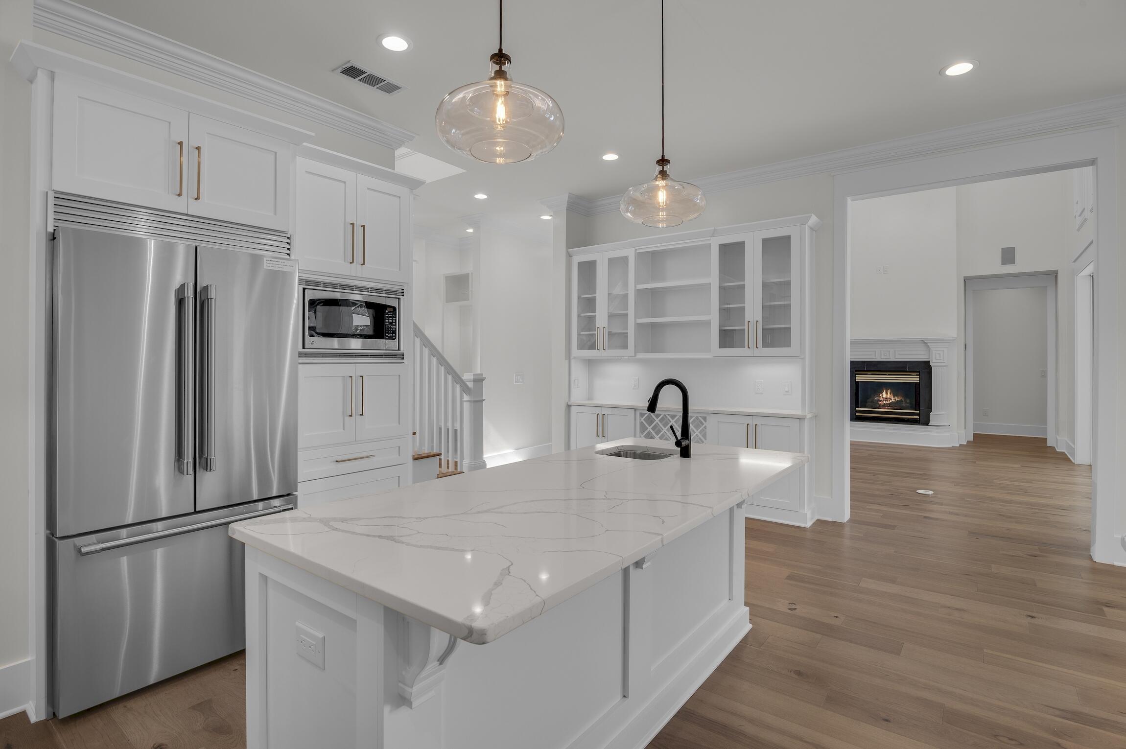 488 Regatta Bay Boulevard Destin, FL 32541 - Photo 16 of 46 a kitchen with stainless steel appliances granite countertop a refrigerator a stove and a sink with wooden floor